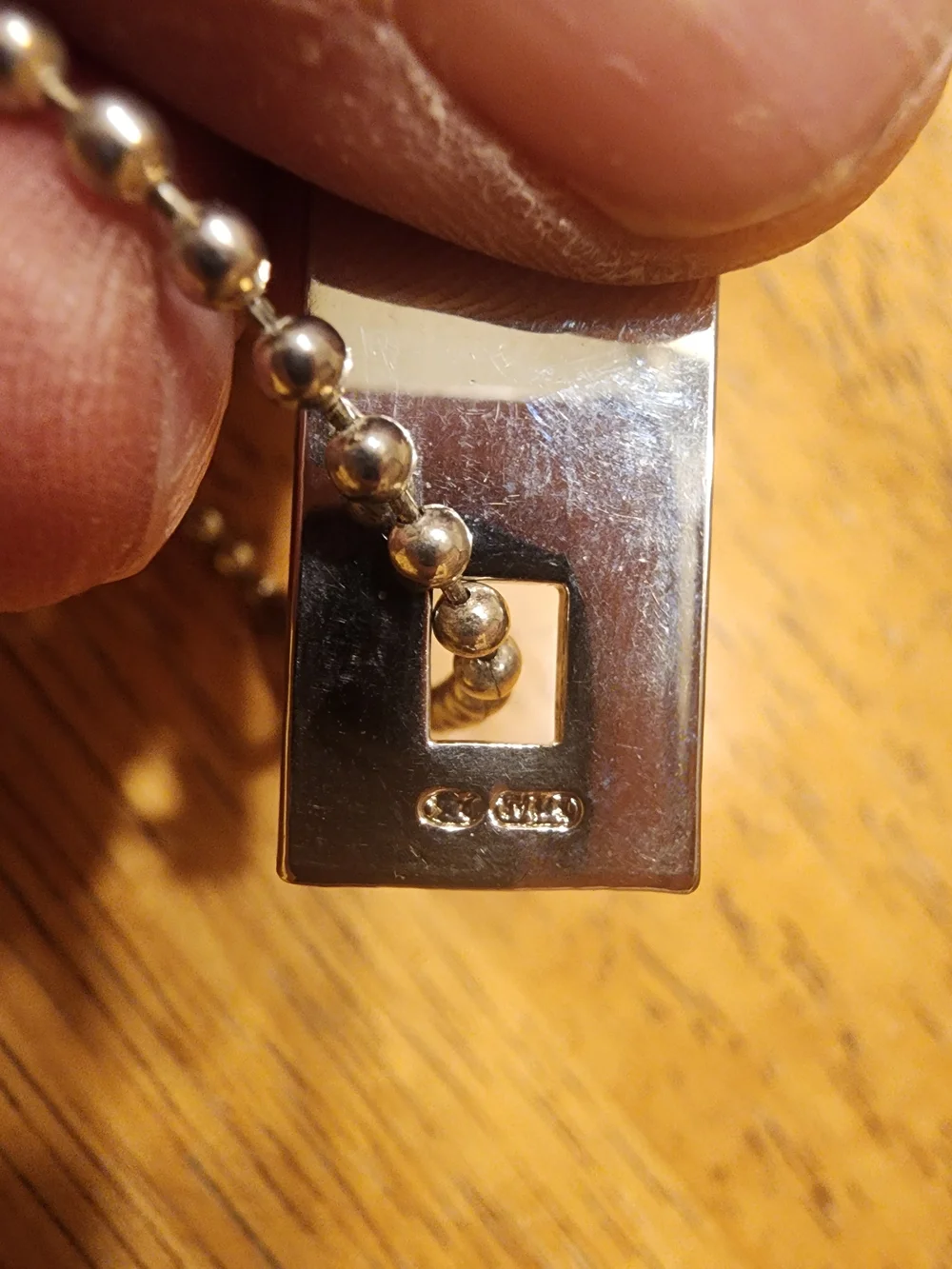 Gucci Sterling Silver Logo Tag likely used on a bracelet or keychain